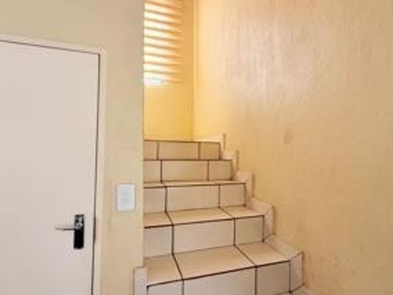 A simple interior staircase featuring tiled steps and a neutral wall finish, providing access between levels.