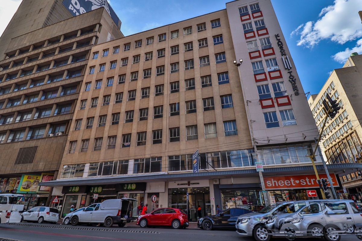 A multi-story commercial building featuring ground-level retail storefronts and a prominent street-facing facade in a busy urban environment.