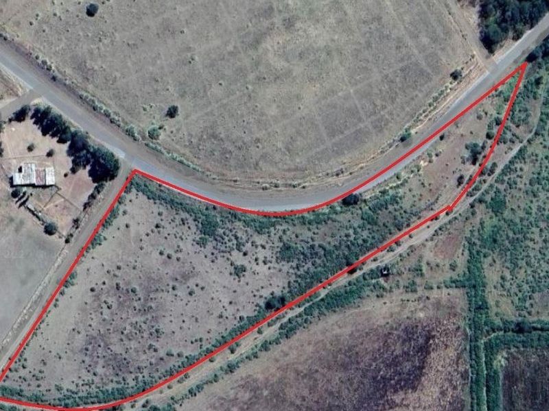 Aerial view of a vacant commercial land parcel with road frontage and defined boundaries.