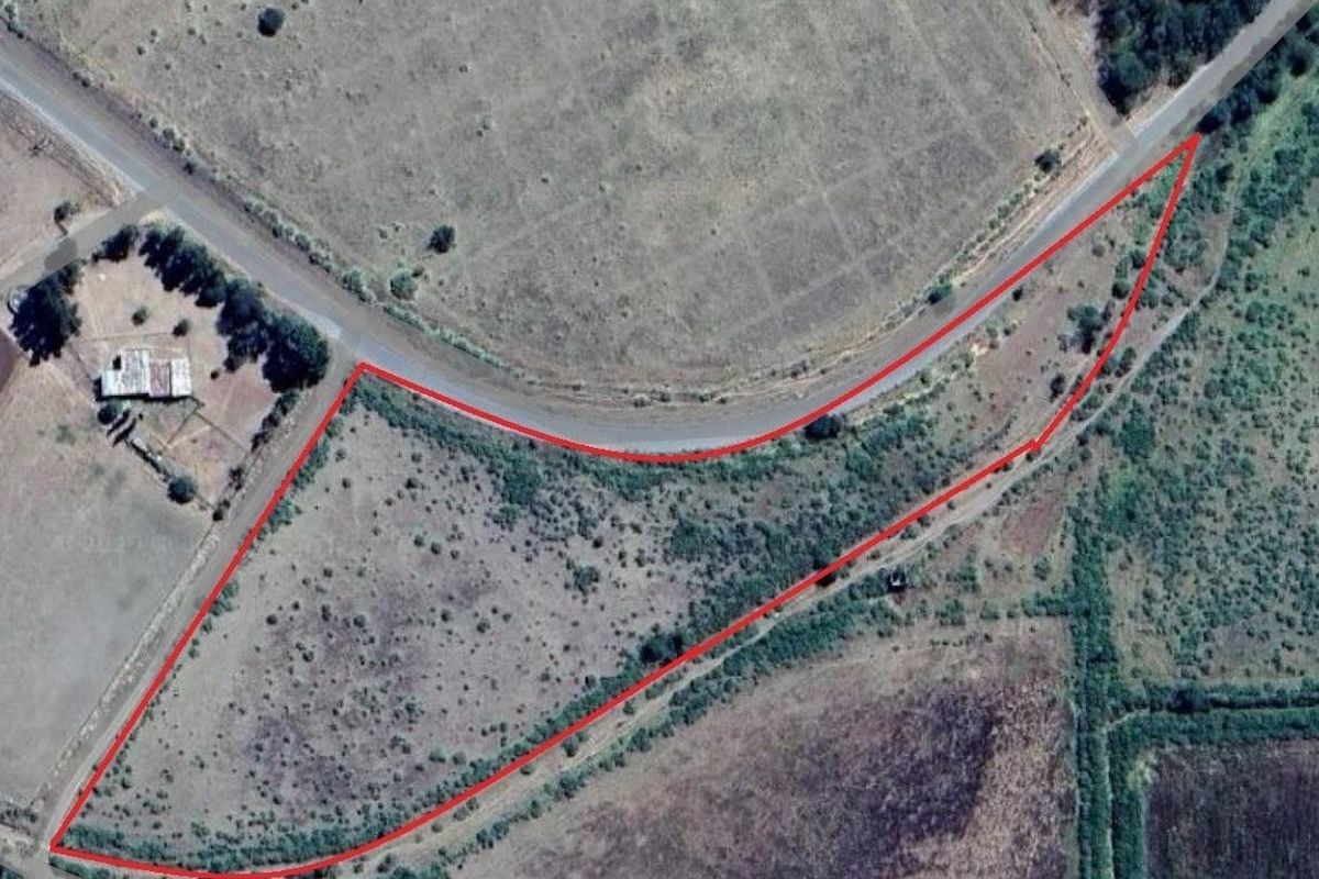 Aerial view of a vacant commercial land parcel with road frontage and defined boundaries.