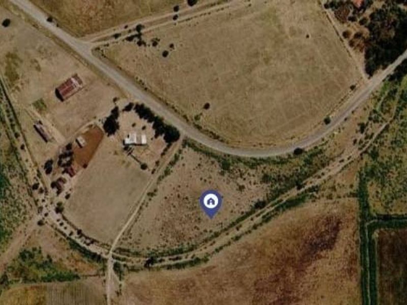 An aerial view of the vacant commercial land plot showing surrounding terrain and access roads.
