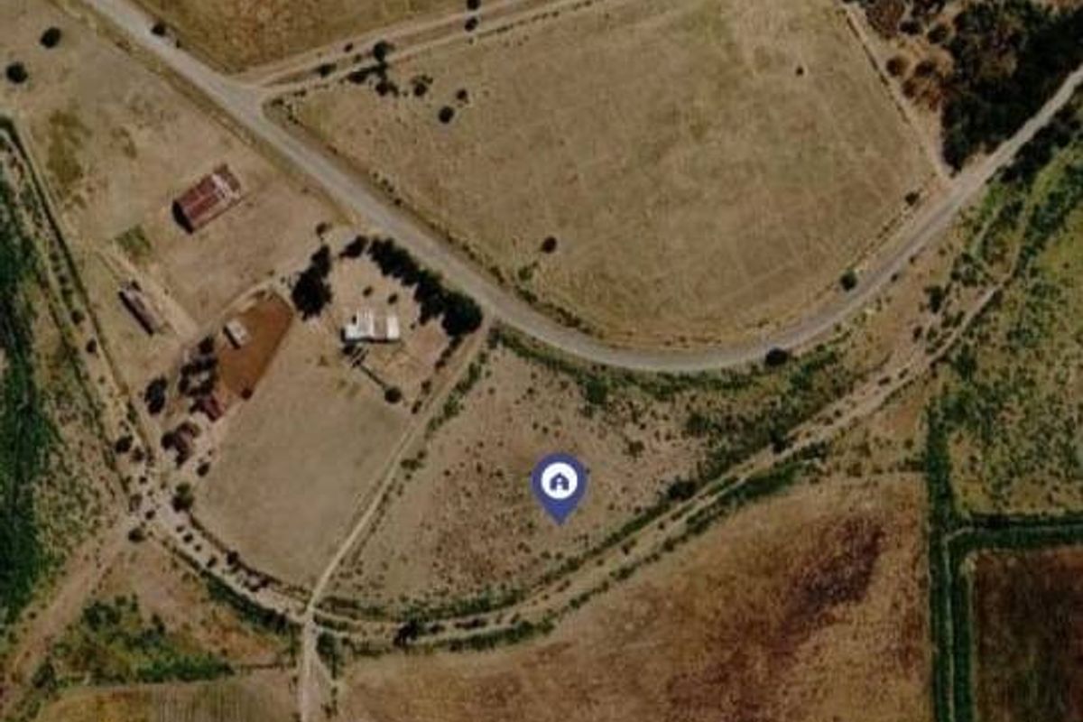 An aerial view of the vacant commercial land plot showing surrounding terrain and access roads.