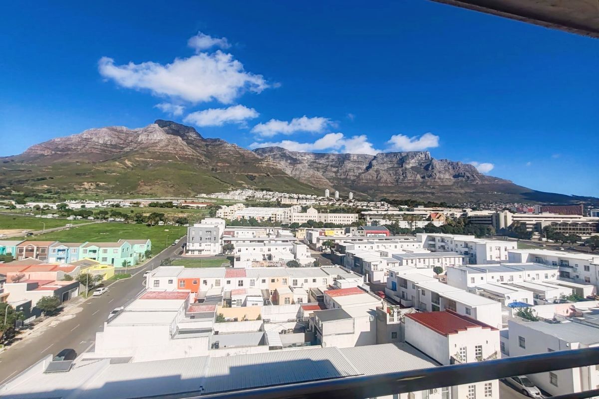 A clear, elevated view of the surrounding residential neighborhood and mountain range, captured from a balcony.