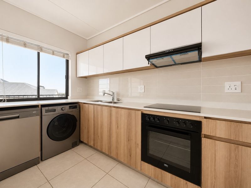 Modern kitchen featuring sleek wood-grain and white cabinetry, stone countertops, integrated appliances, and a tiled backsplash with ample natural light.