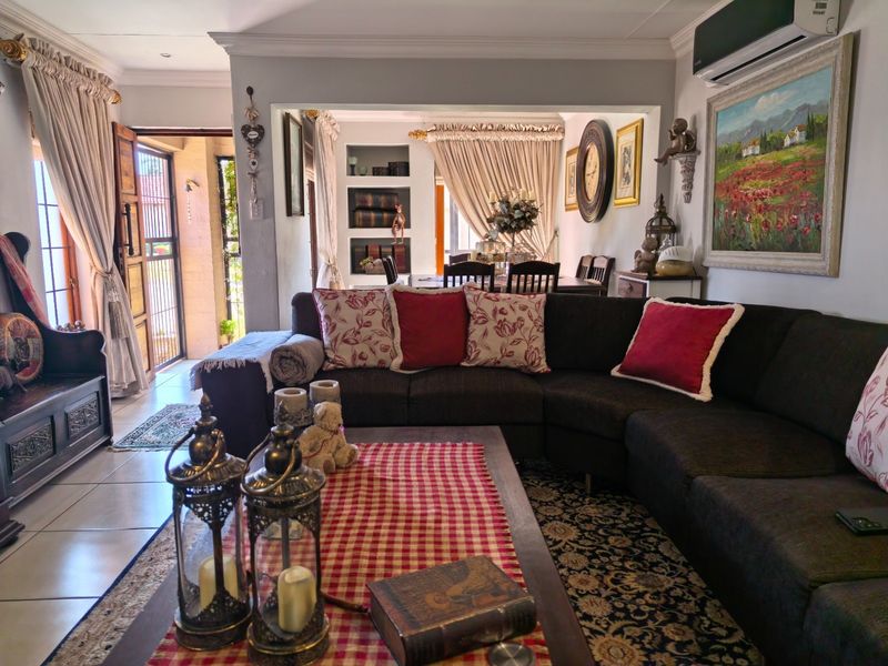 Spacious open-plan living and dining area featuring tiled flooring, built-in shelving, and an integrated air conditioning unit, creating a comfortable and connected living space.