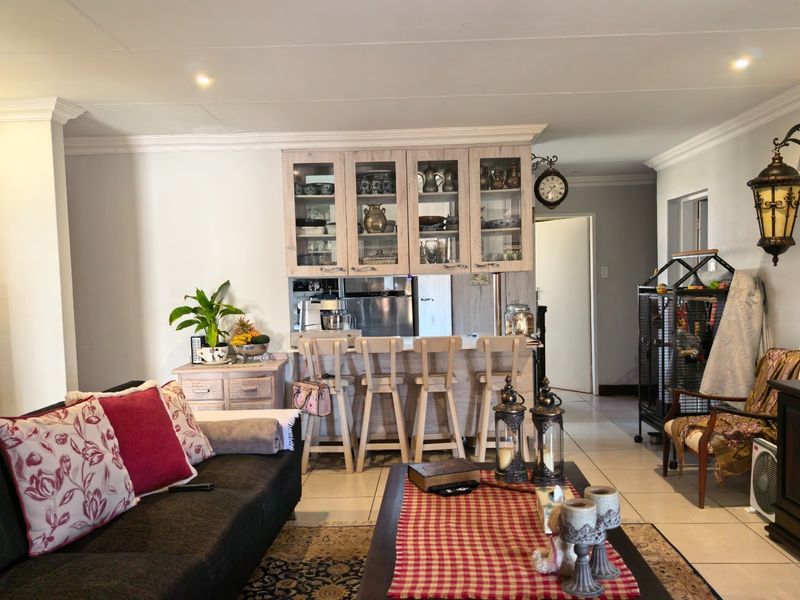 Open plan living area featuring a breakfast bar with built-in cabinetry and tiled flooring, creating a functional and connected space.