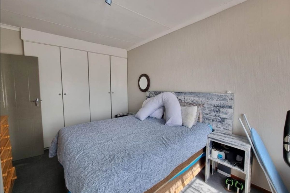 A functional bedroom featuring built-in cupboards and neutral wall finishes, providing a practical space with standard residential fixtures.