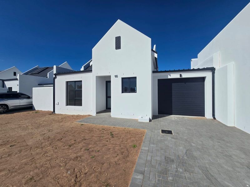 Modern single-story home featuring a gabled facade, paved driveway, and integrated single garage, set within a contemporary residential development.