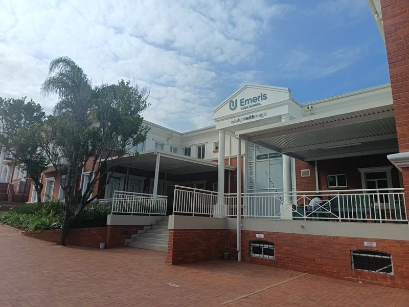 Front elevation of the office building featuring a brick facade, covered patio area, and paved entrance with professional signage.