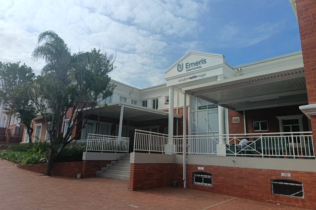Front elevation of the office building featuring a brick facade, covered patio area, and paved entrance with professional signage.