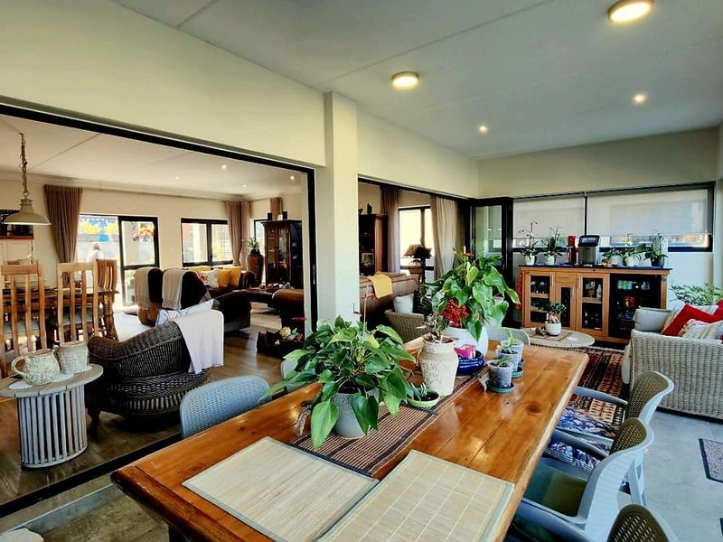 Spacious open-plan living and dining area featuring large sliding glass doors that provide seamless indoor-outdoor flow and abundant natural light.