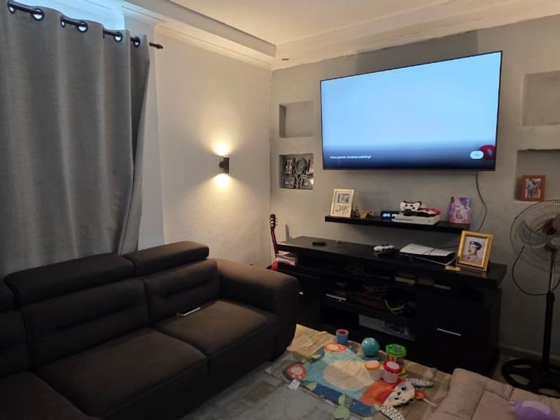 A cozy living room featuring recessed wall niches, coved ceiling details, and wall-mounted lighting, creating a comfortable and functional space.