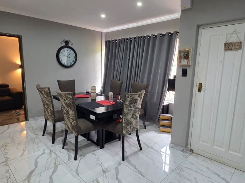 Dining area featuring modern marble-look floor tiles, recessed downlighting, and a wall-mounted split-system air conditioner.