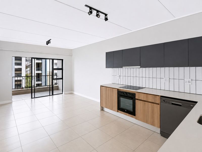 Modern open-plan kitchen and living area featuring sleek cabinetry, built-in appliances, tiled flooring, and direct access to a private balcony.