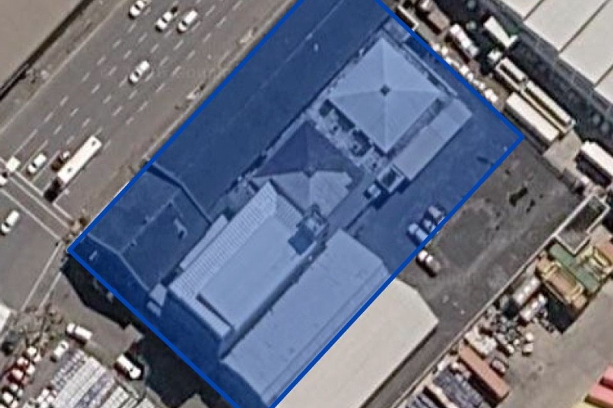 An aerial view of the commercial property highlighting the building footprint and surrounding paved parking area.