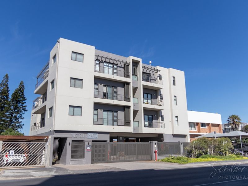 Modern multi-story apartment building facade featuring balconies, secure gated access, and contemporary architectural finishes.