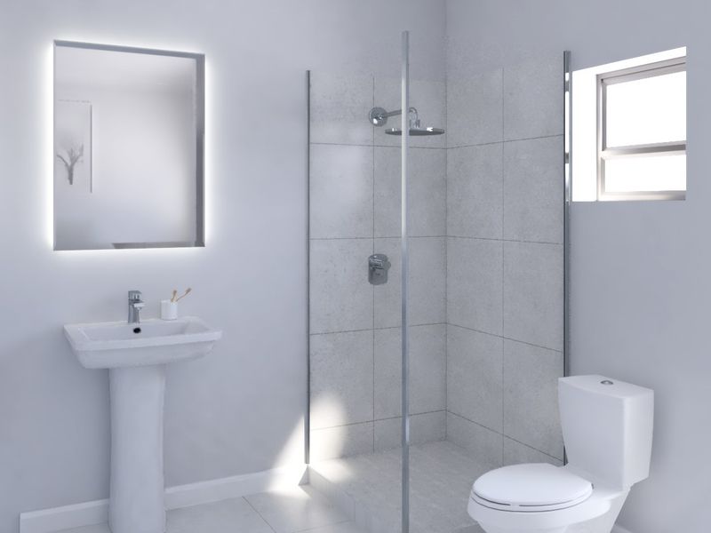 A modern, clean bathroom featuring a pedestal basin, glass-enclosed shower, and toilet, finished with neutral tiling and a contemporary backlit mirror.