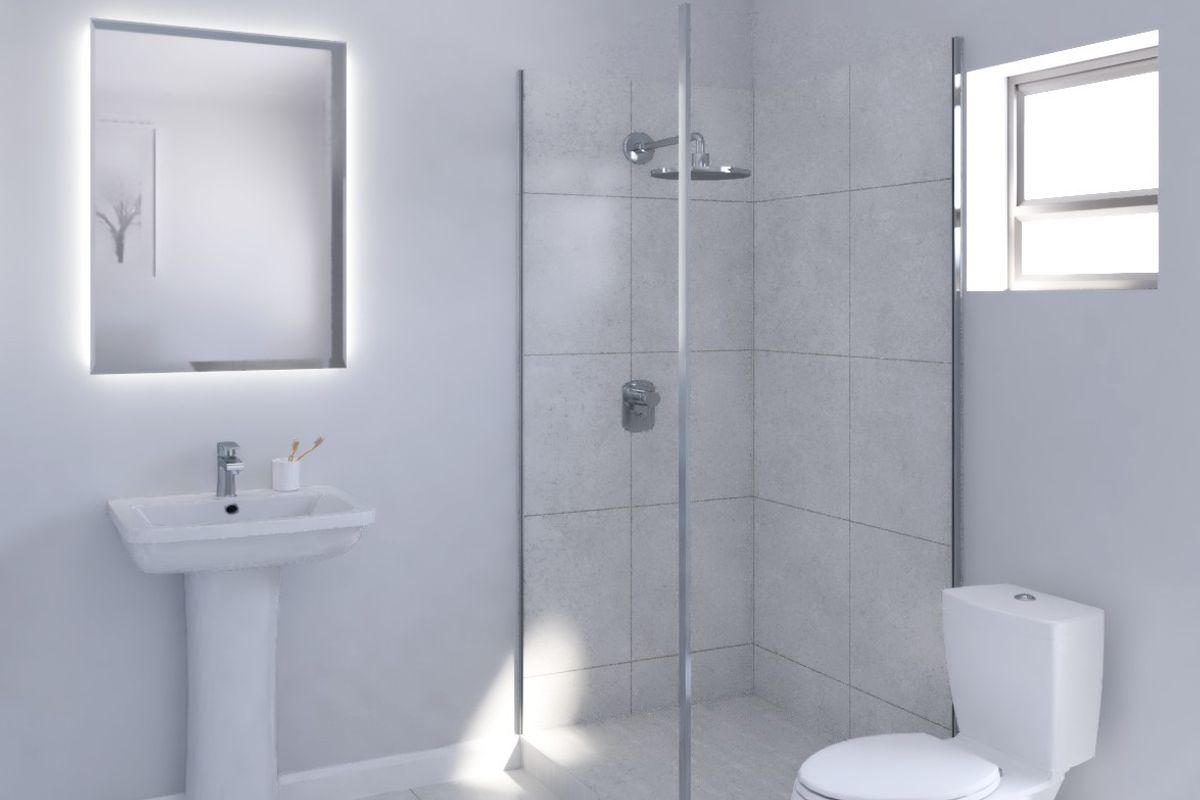 A modern, clean bathroom featuring a pedestal basin, glass-enclosed shower, and toilet, finished with neutral tiling and a contemporary backlit mirror.