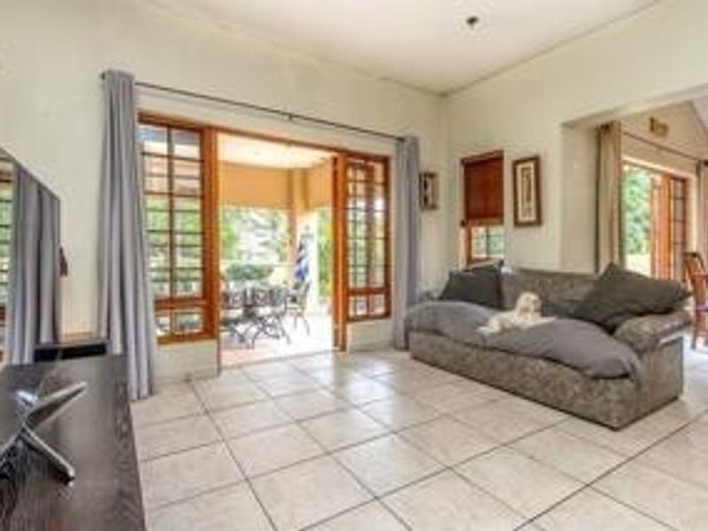 Spacious living room featuring tiled flooring and large sliding glass doors that provide seamless access to the outdoor patio area.
