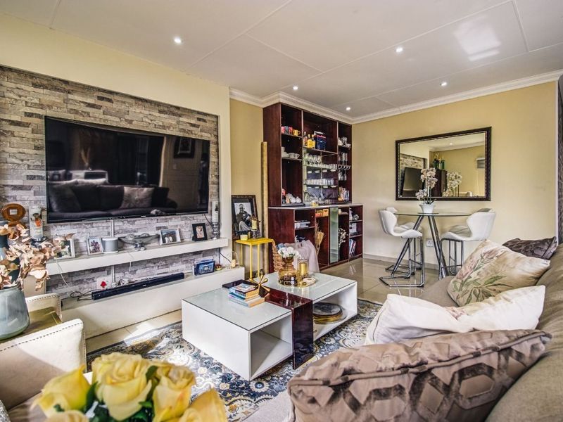A well-maintained living room featuring a stone veneer accent wall, recessed lighting, and built-in cabinetry, creating a comfortable and functional living space.