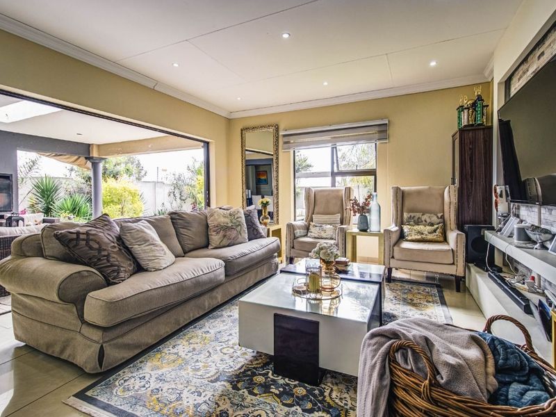 Spacious living room featuring tiled floors, recessed lighting, and large sliding doors that provide seamless access to the outdoor patio area.