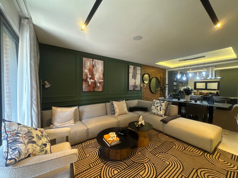 A modern open-plan living and dining area featuring elegant wainscoting, an exposed brick feature wall, and sophisticated recessed and pendant lighting.