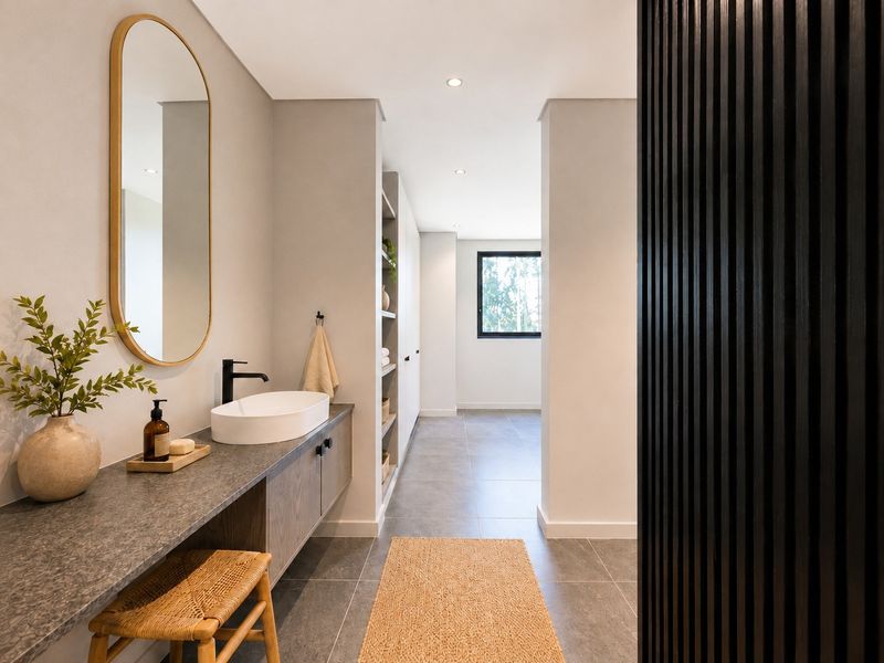 Modern bathroom featuring a sleek vanity with vessel sink, stone-look countertop, built-in storage shelving, and contemporary dark wood slat wall detailing.