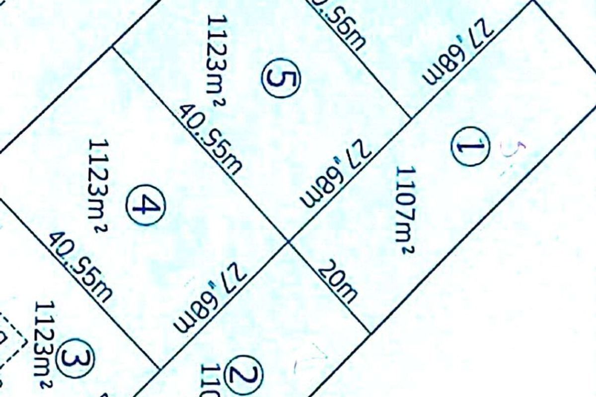 A site plan showing the subdivision layout of residential plots, including individual land sizes and the location of an existing garage.