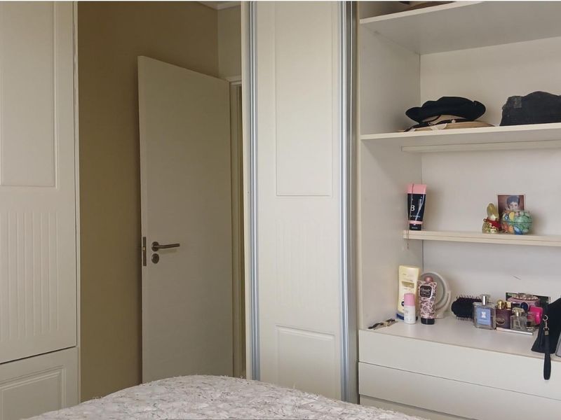 A bedroom featuring built-in wardrobes with integrated shelving and storage space.