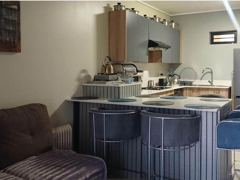 Open plan kitchen and living area featuring a central island with breakfast bar seating and modern cabinetry.