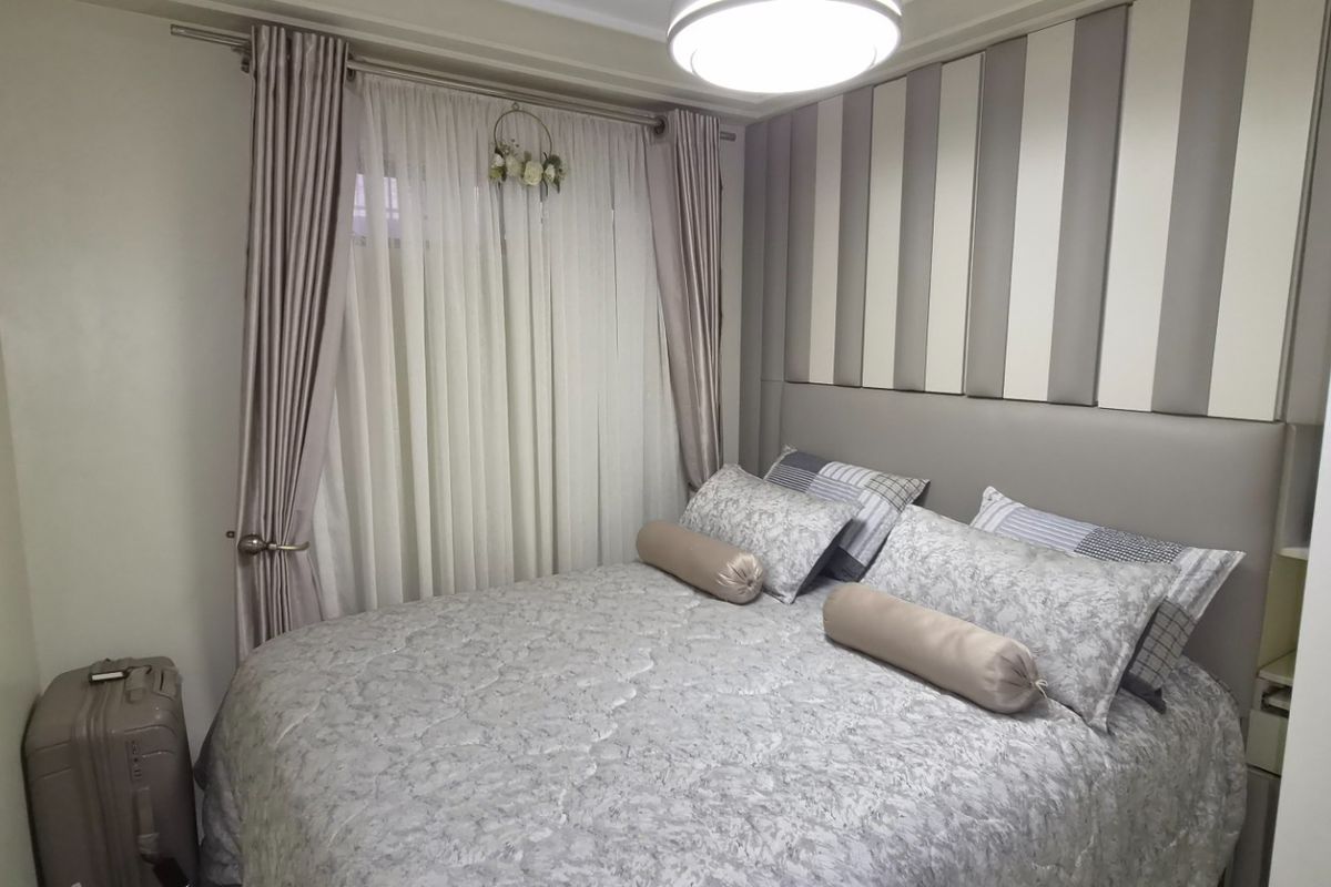 A cozy bedroom featuring a built-in headboard and neutral wall finishes, providing a comfortable and well-maintained sleeping space.