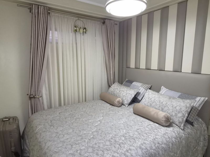 A cozy bedroom featuring a built-in headboard and neutral wall finishes, providing a comfortable and well-maintained sleeping space.