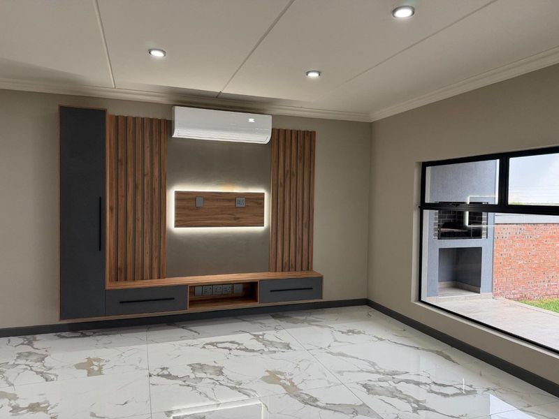 Modern living room featuring high-end marble-look floor tiles, custom timber slat media wall with integrated lighting, and a split-system air conditioner.