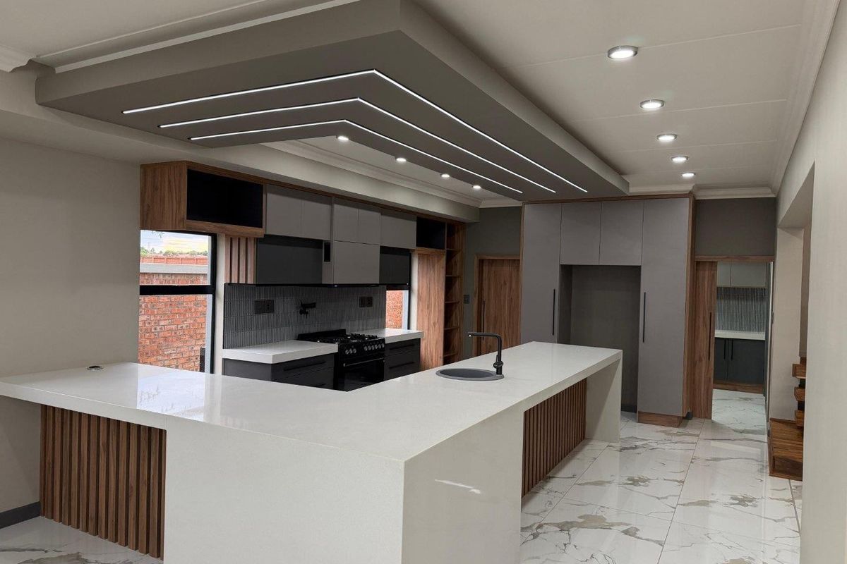 Modern, high-end kitchen featuring a large island with quartz countertops, custom cabinetry, integrated lighting, and premium finishes throughout.