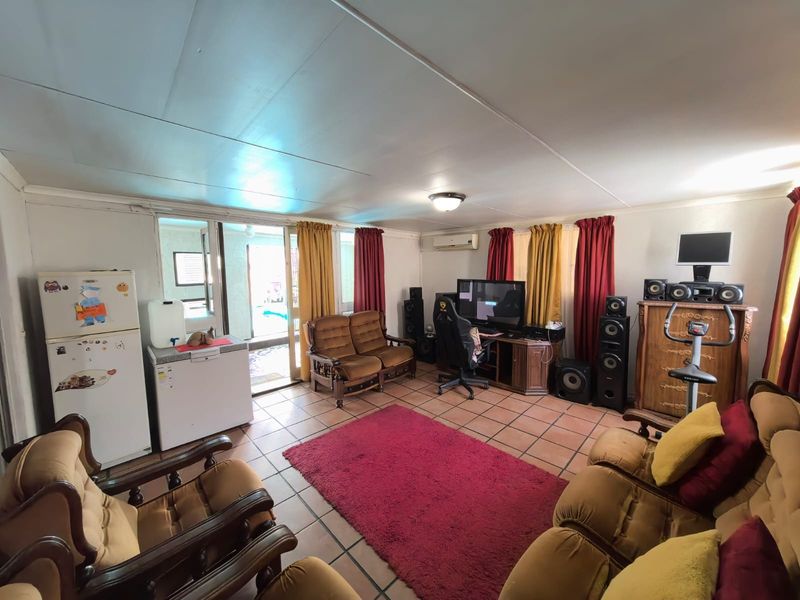 Spacious living area featuring tiled flooring, a split-system air conditioner, and direct access to an outdoor patio through sliding glass doors.