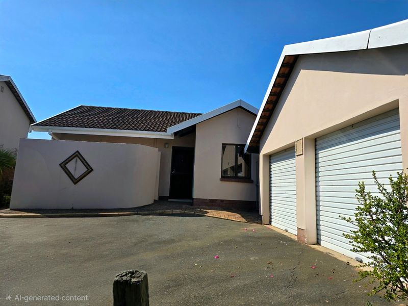 Front exterior view of a townhouse featuring a double garage, paved driveway, and a private entrance courtyard.