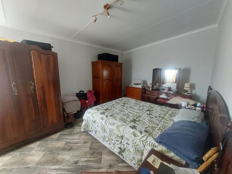 A bedroom featuring tiled flooring and a central ceiling light fixture, providing a functional space for rest.