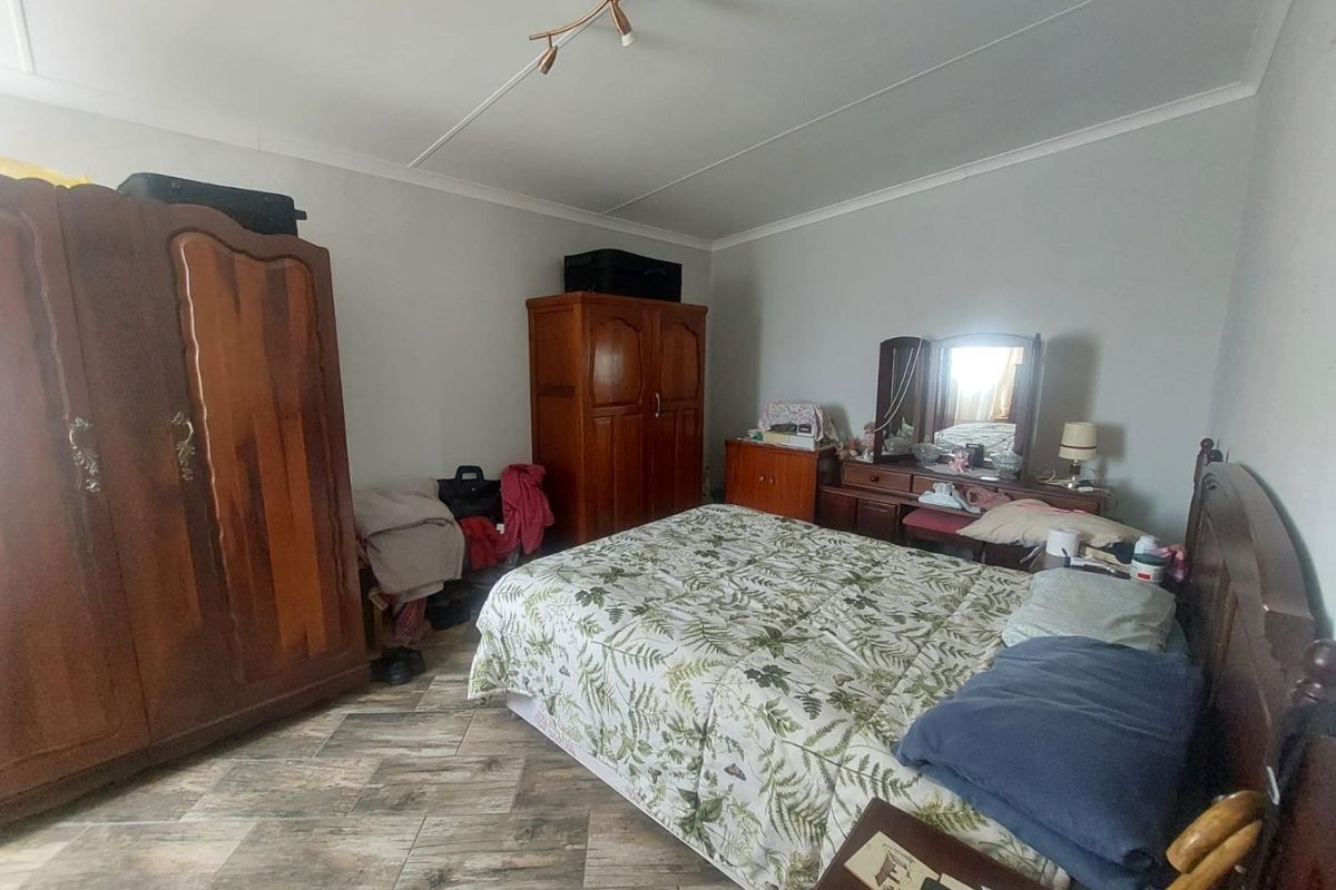 A bedroom featuring tiled flooring and a central ceiling light fixture, providing a functional space for rest.