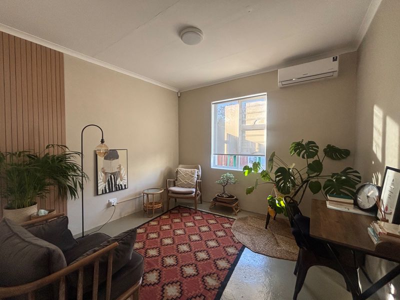 A well-maintained office space featuring neutral walls, slatted wood accent paneling, and a wall-mounted air conditioning unit.