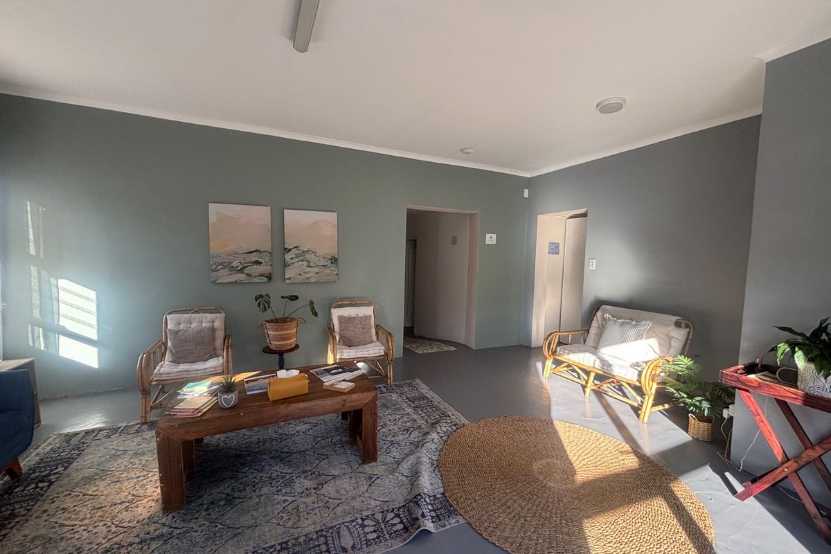 A bright and spacious commercial waiting area or lounge featuring smooth concrete floors, neutral painted walls, and recessed ceiling lighting.