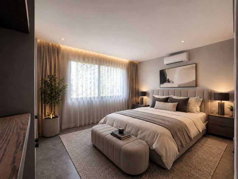 A modern, well-appointed bedroom featuring tiled flooring, recessed lighting, and a wall-mounted air conditioning unit, creating a comfortable and contemporary living space.