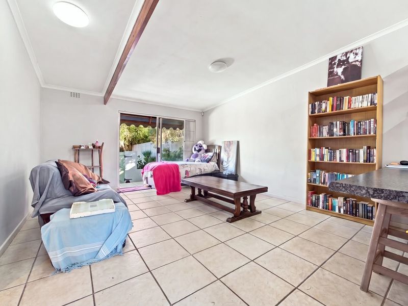 Spacious living area featuring tiled flooring and a sliding glass door providing access to the outdoor space.