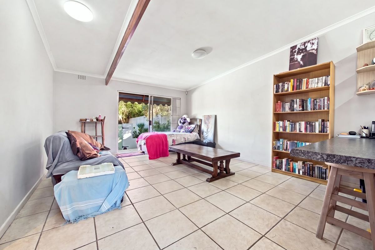 Spacious living area featuring tiled flooring and a sliding glass door providing access to the outdoor space.
