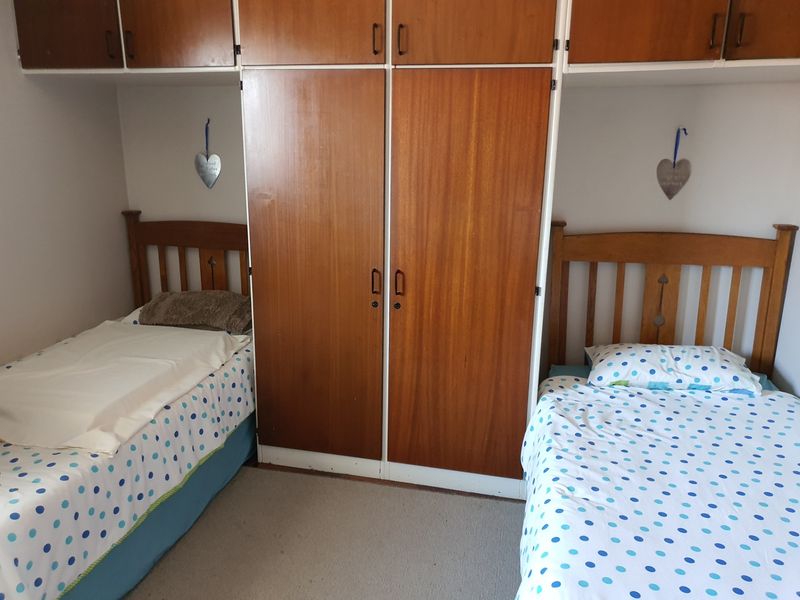 Bedroom featuring extensive built-in wooden cabinetry and overhead storage units, providing ample storage space.
