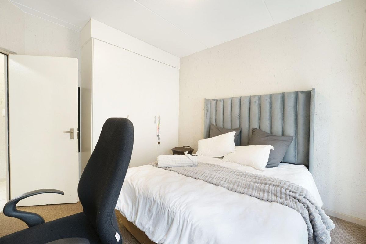 A functional bedroom featuring a built-in wardrobe and neutral wall finishes, providing a comfortable and practical living space.