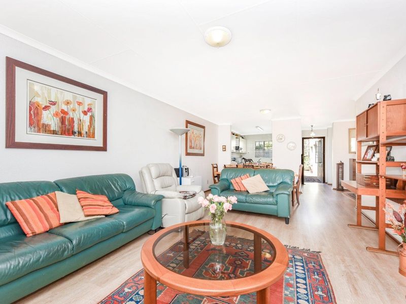 Spacious open-plan living and dining area featuring light-toned laminate flooring and neutral wall finishes, providing a versatile layout for comfortable family living.