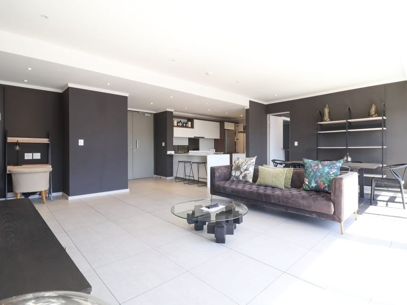 Spacious open-plan living area featuring modern tiled flooring, recessed lighting, and a contemporary kitchen with a central island and integrated cabinetry.