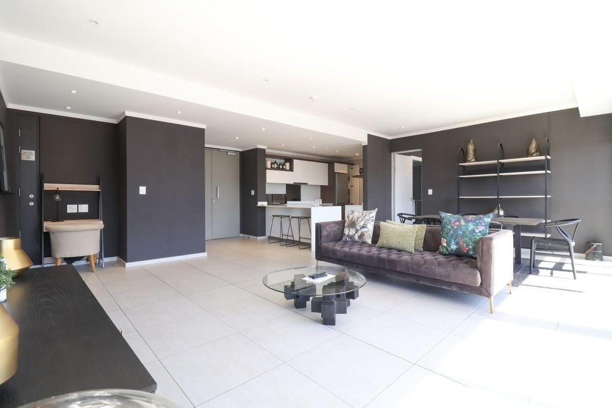Spacious open-plan living area featuring modern tiled flooring, recessed lighting, and a contemporary kitchen with a central island and integrated cabinetry.
