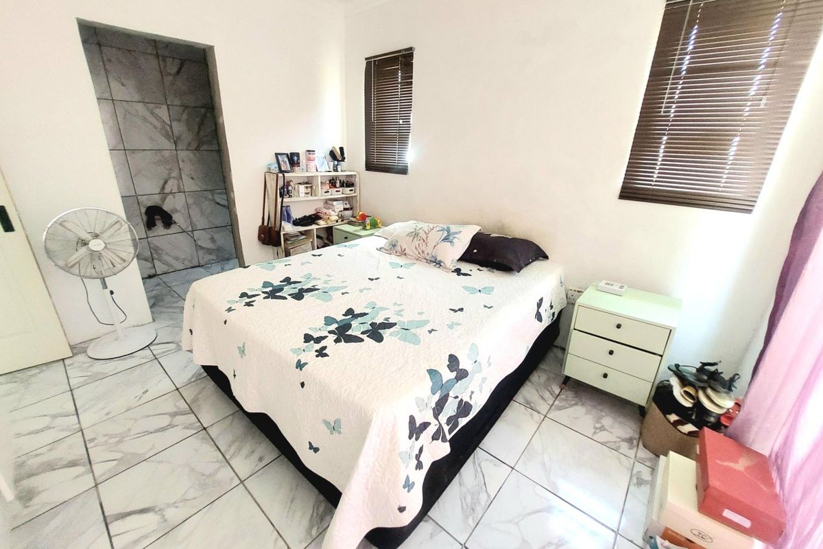 A bedroom featuring tiled flooring, venetian blinds, and direct access to an en-suite bathroom area.