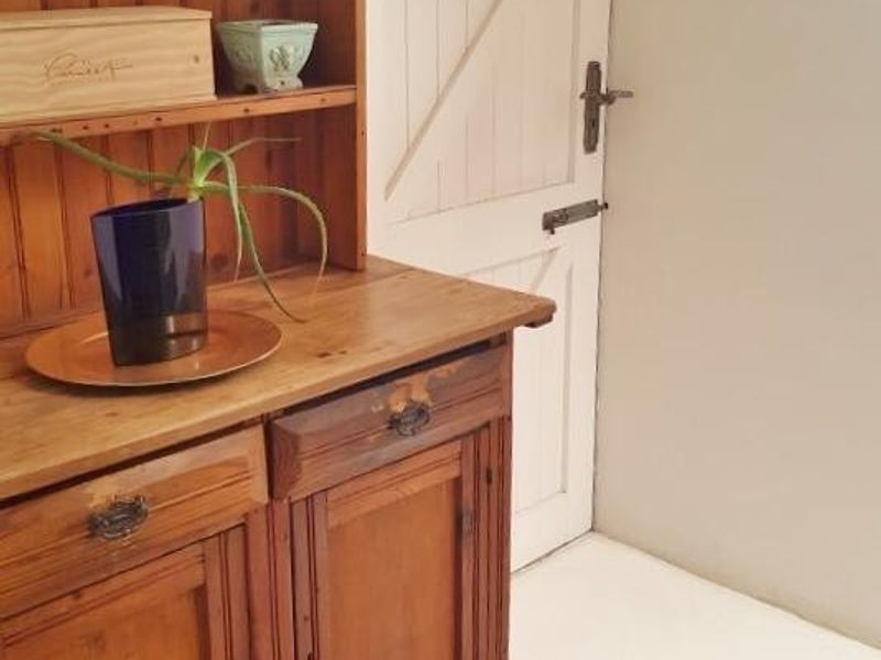 A hallway area featuring a distinctive arched doorway with a rustic timber door and neutral wall finishes.